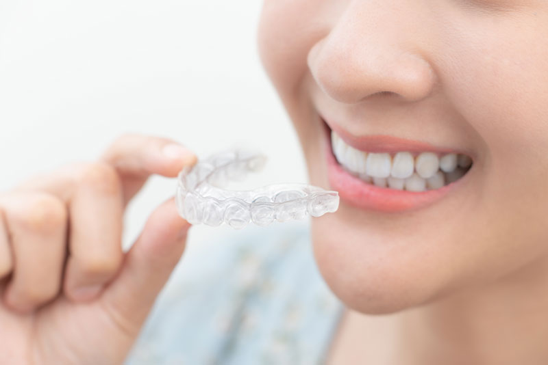 a dental patient holding clear aligners.